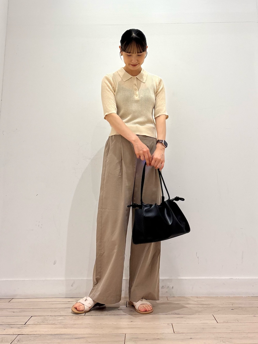 ホワイト系のニット/セーター、ベージュ系のその他パンツ、ブラック系のトートバッグを着用したレディースの夏コーディネートの2枚目の写真