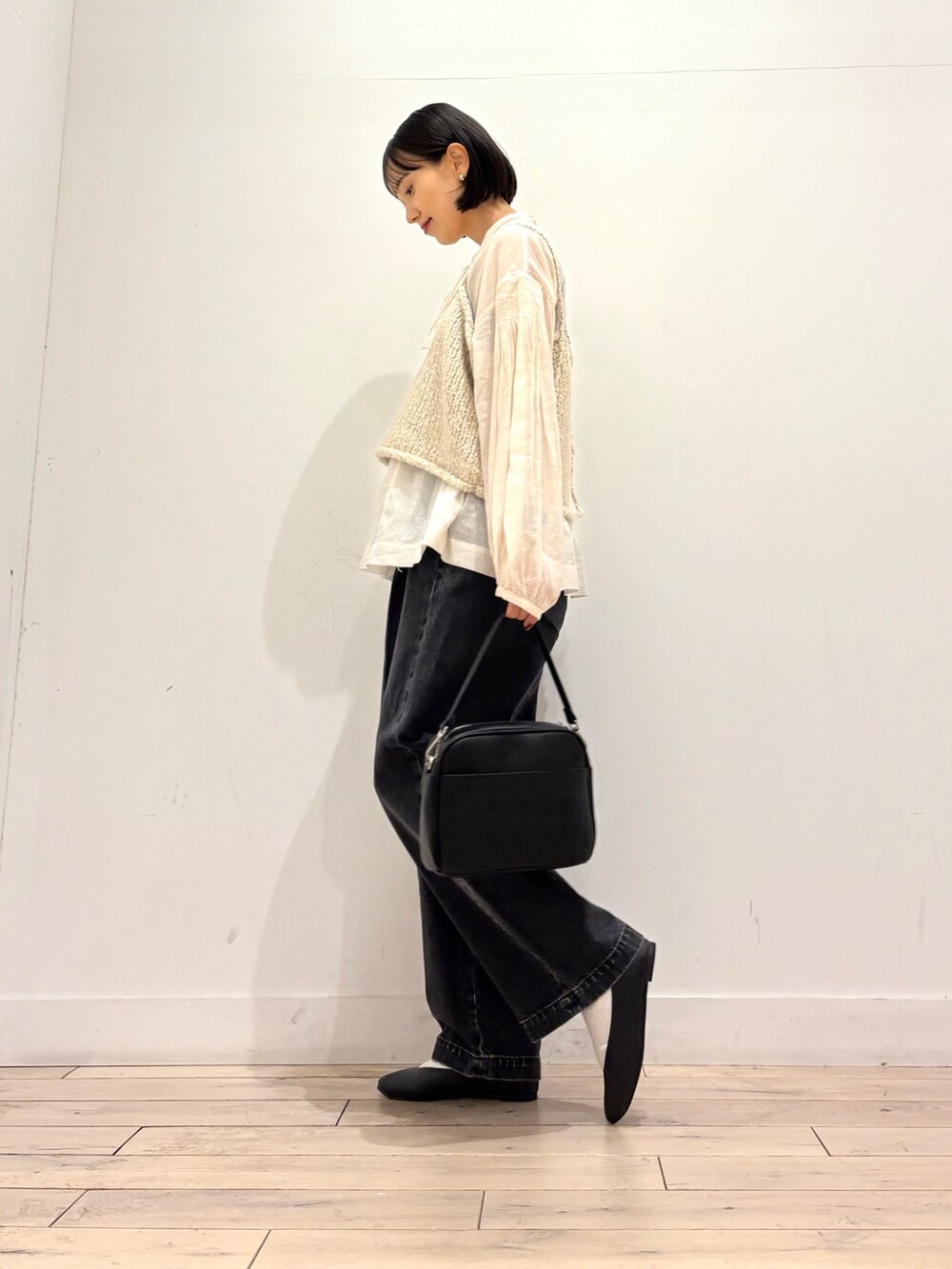 パープル系のニット/セーター、ホワイト系のシャツ/ブラウス、ブラック系のショルダーバッグを着用したレディースの秋コーディネートの3枚目の写真