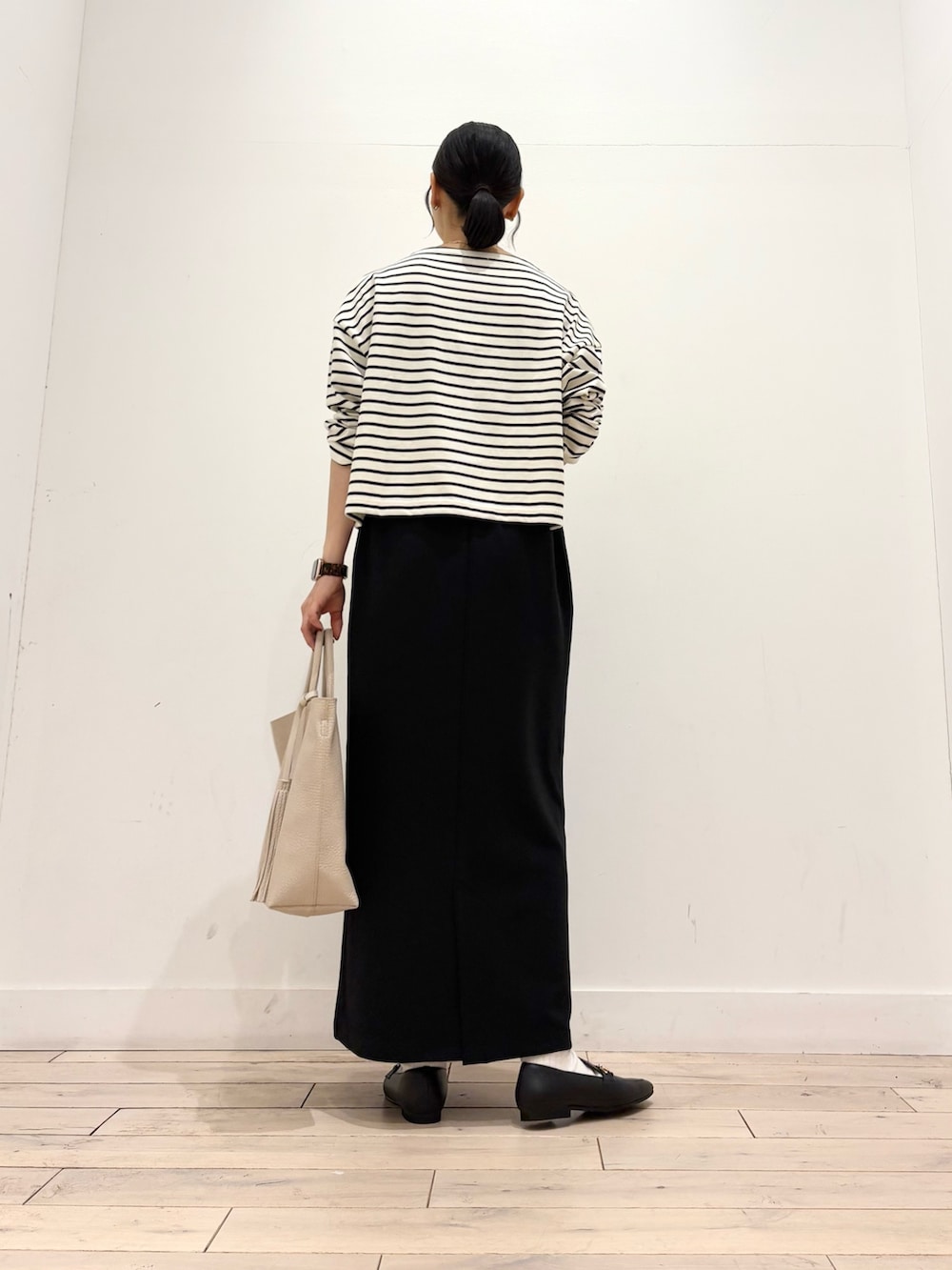 ホワイト系のTシャツ/カットソー、ブラック系のスカート、ホワイト系のトートバッグを着用したレディースの秋コーディネートの3枚目の写真