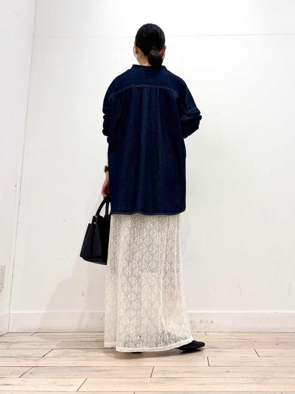 ホワイト系のTシャツ/カットソー、ホワイト系のスカート、ブラック系のトートバッグを着用したレディースの冬コーディネートの4枚目の写真