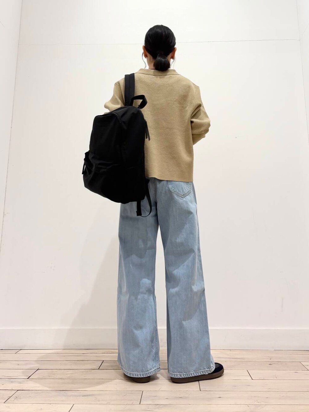 ホワイト系のタンクトップ、ブラック系のバックパック/リュック、ベージュ系のカーディガン/ボレロを着用したレディースの春コーディネートの4枚目の写真