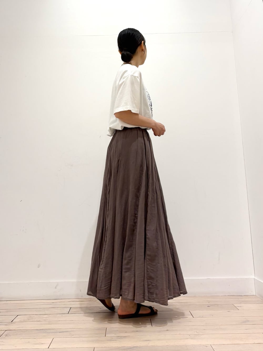 ホワイト系のTシャツ/カットソー、グレー系のスカート、ブラック系のショルダーバッグを着用したレディースの夏コーディネートの3枚目の写真