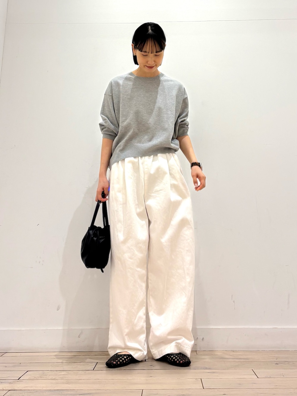 グレー系のTシャツ/カットソー、ブラック系のショルダーバッグ、ブラック系のサンダルを着用したレディースの春コーディネートの3枚目の写真