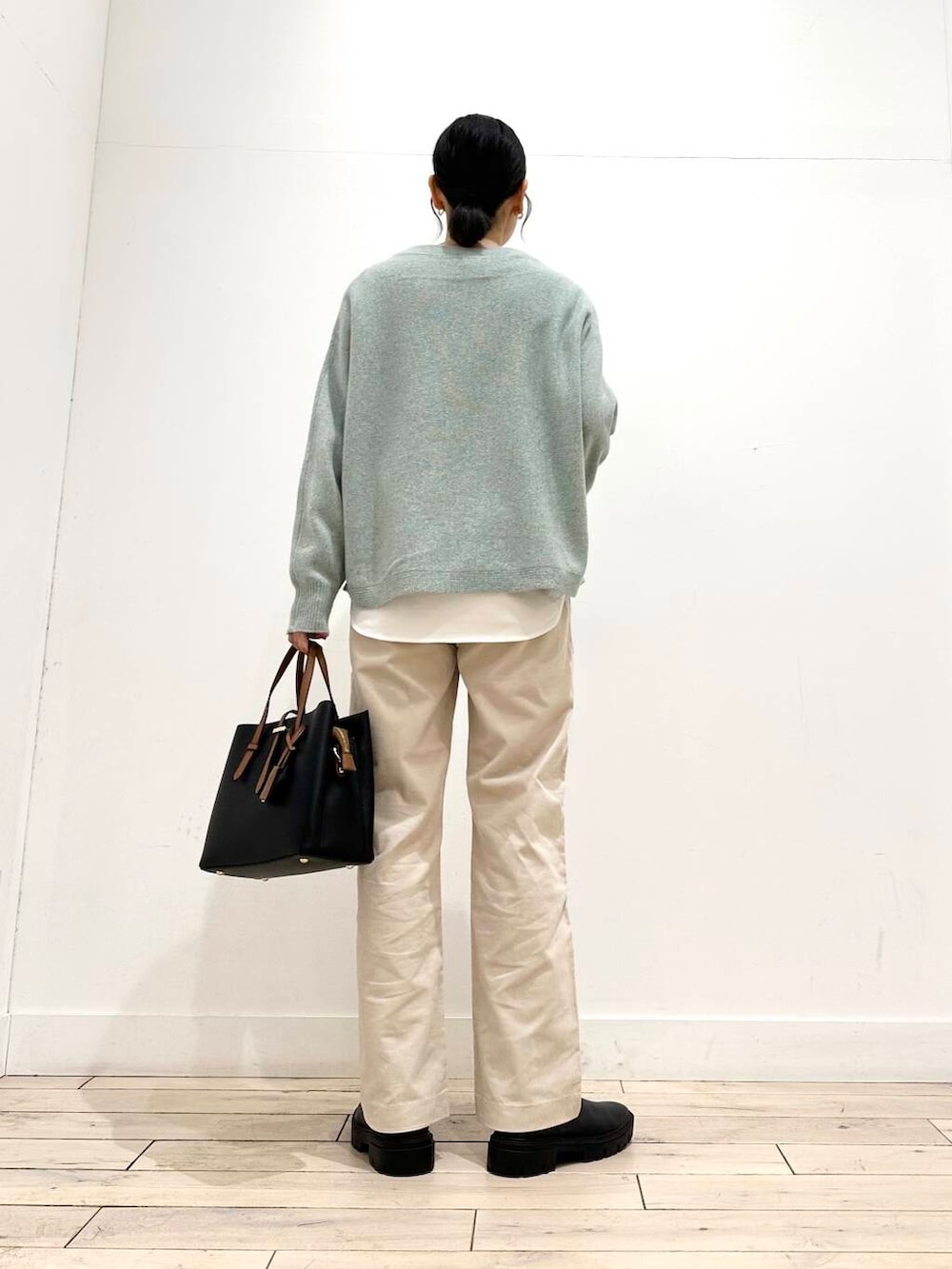 ブラック系のトートバッグ、グリーン系のニット/セーター、ブラック系のブーツを着用したレディースの冬コーディネートの4枚目の写真