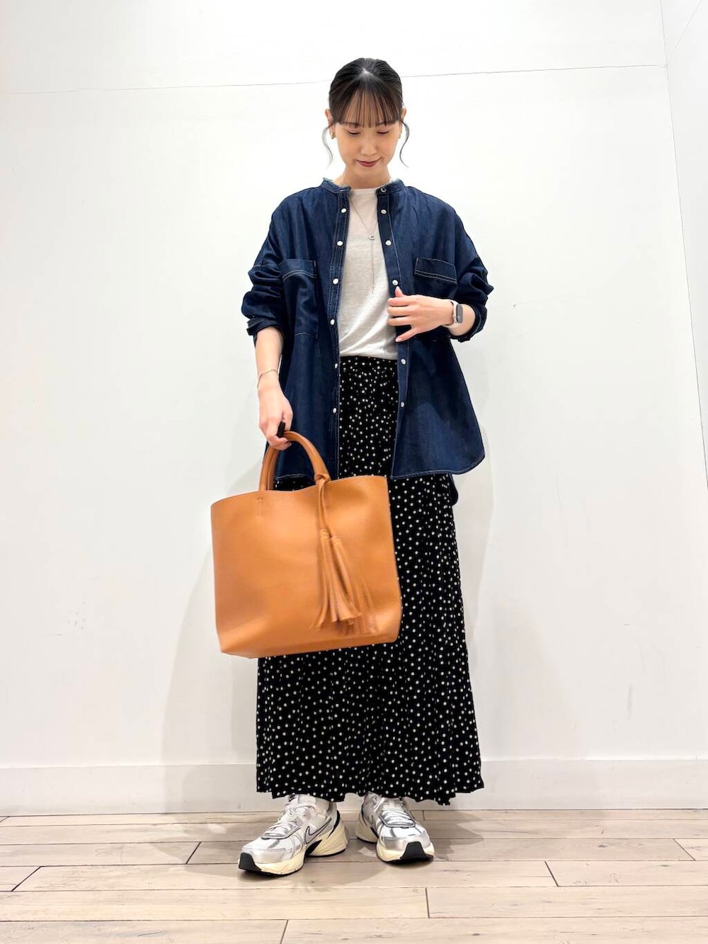 イエロー系のトートバッグ、ホワイト系のスニーカー、グレー系のTシャツ/カットソーを着用したレディースの冬コーディネートの2枚目の写真