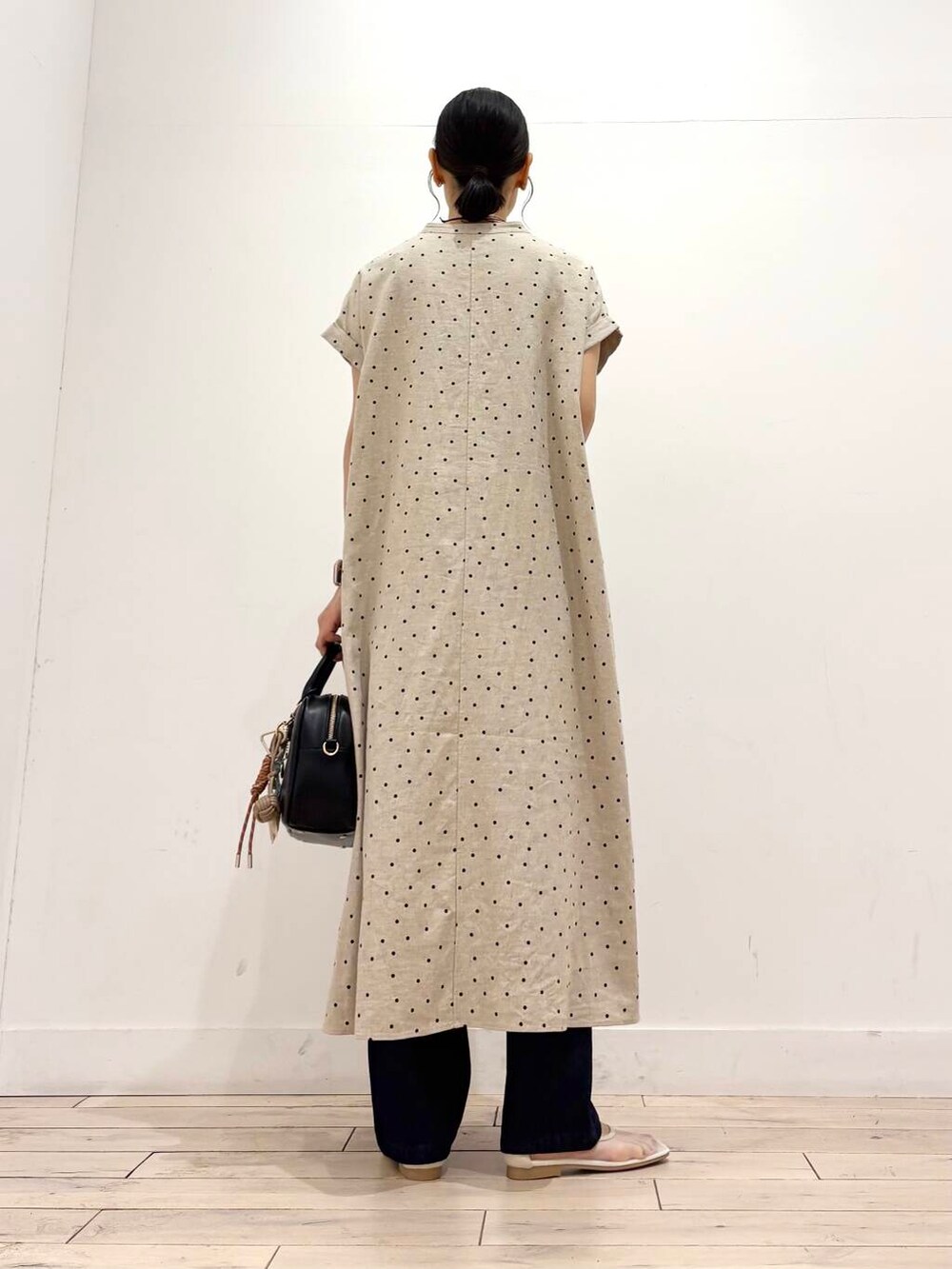 ブルー系のデニムパンツ、ホワイト系のバレエシューズ、ブラック系のボストンバッグを着用したレディースの夏コーディネートの4枚目の写真