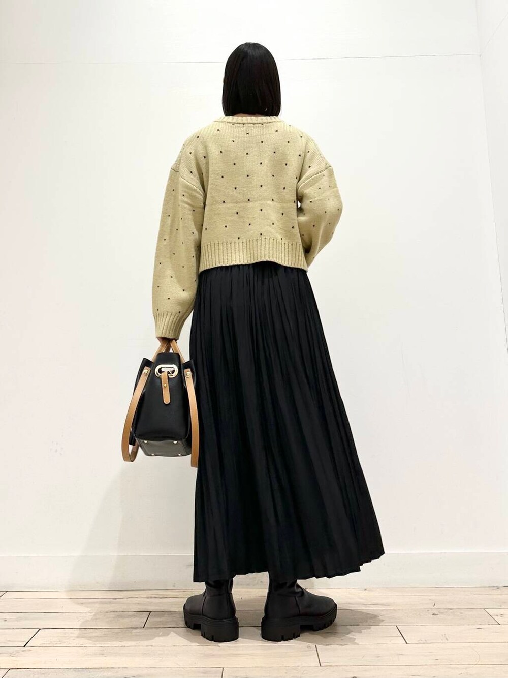 ブラック系のトートバッグ、ブラック系のブーツ、ブラック系のスカートを着用したレディースの秋コーディネートの4枚目の写真