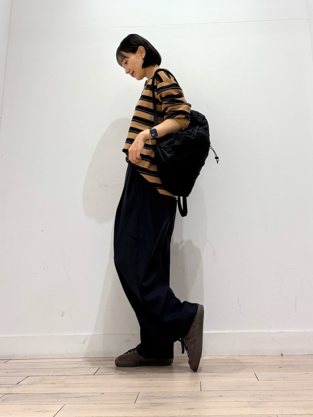 ブラウン系のニット/セーター、ブルー系のその他パンツ、ブラウン系のスニーカーを着用したレディースの秋コーディネートの2枚目の写真