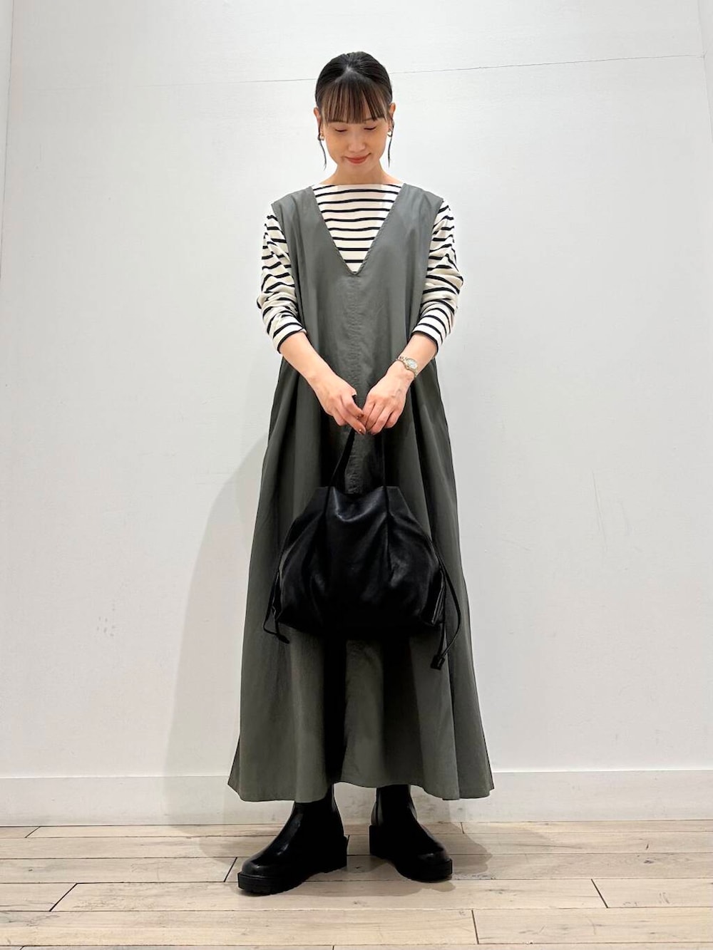 ブラック系のショルダーバッグ、ブルー系のTシャツ/カットソー、グリーン系のワンピースを着用したレディースの秋コーディネートの2枚目の写真