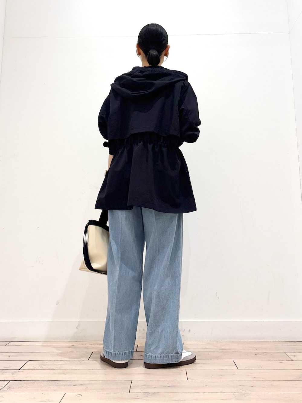 ホワイト系のTシャツ/カットソー、ブルー系のマウンテンパーカー、ブルー系のデニムパンツを着用したレディースの春コーディネートの4枚目の写真