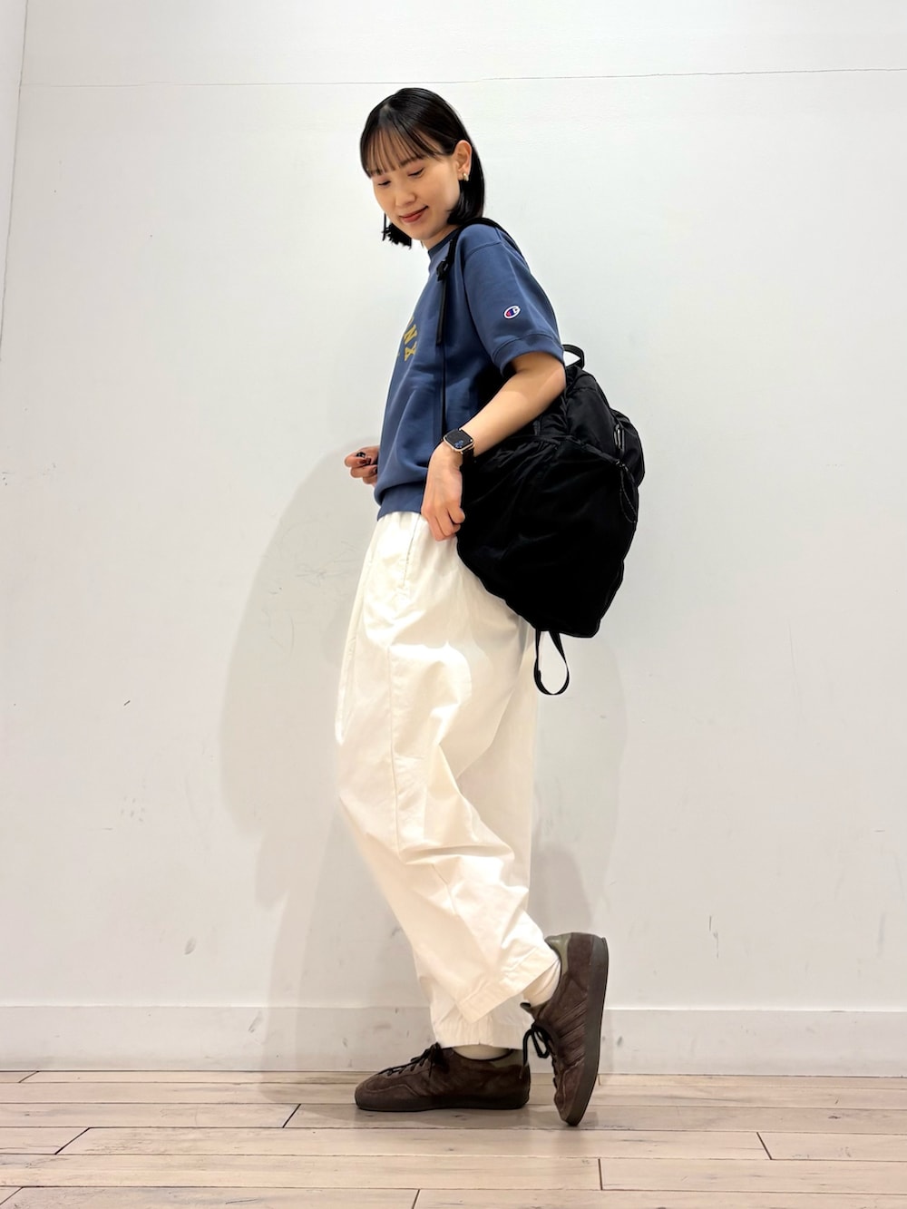 ブルー系のスウェット、ホワイト系のその他パンツ、ブラック系のバックパック/リュックを着用したレディースの春コーディネートの3枚目の写真