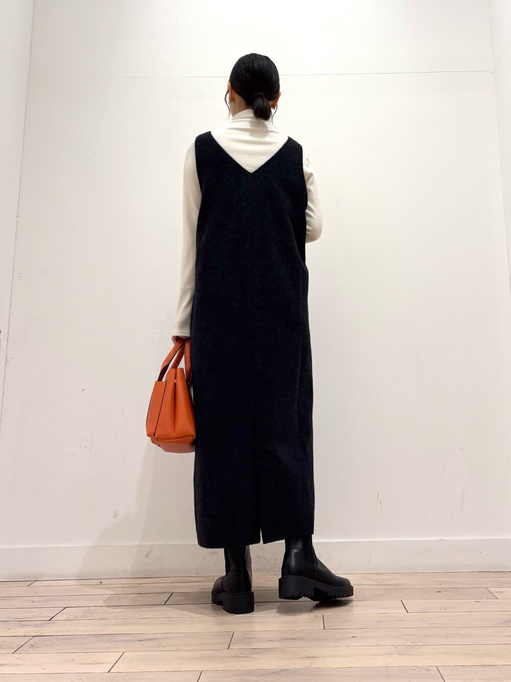 ブラック系のブーツ、オレンジ系のトートバッグ、グレー系のワンピースを着用したレディースの秋コーディネートの7枚目の写真