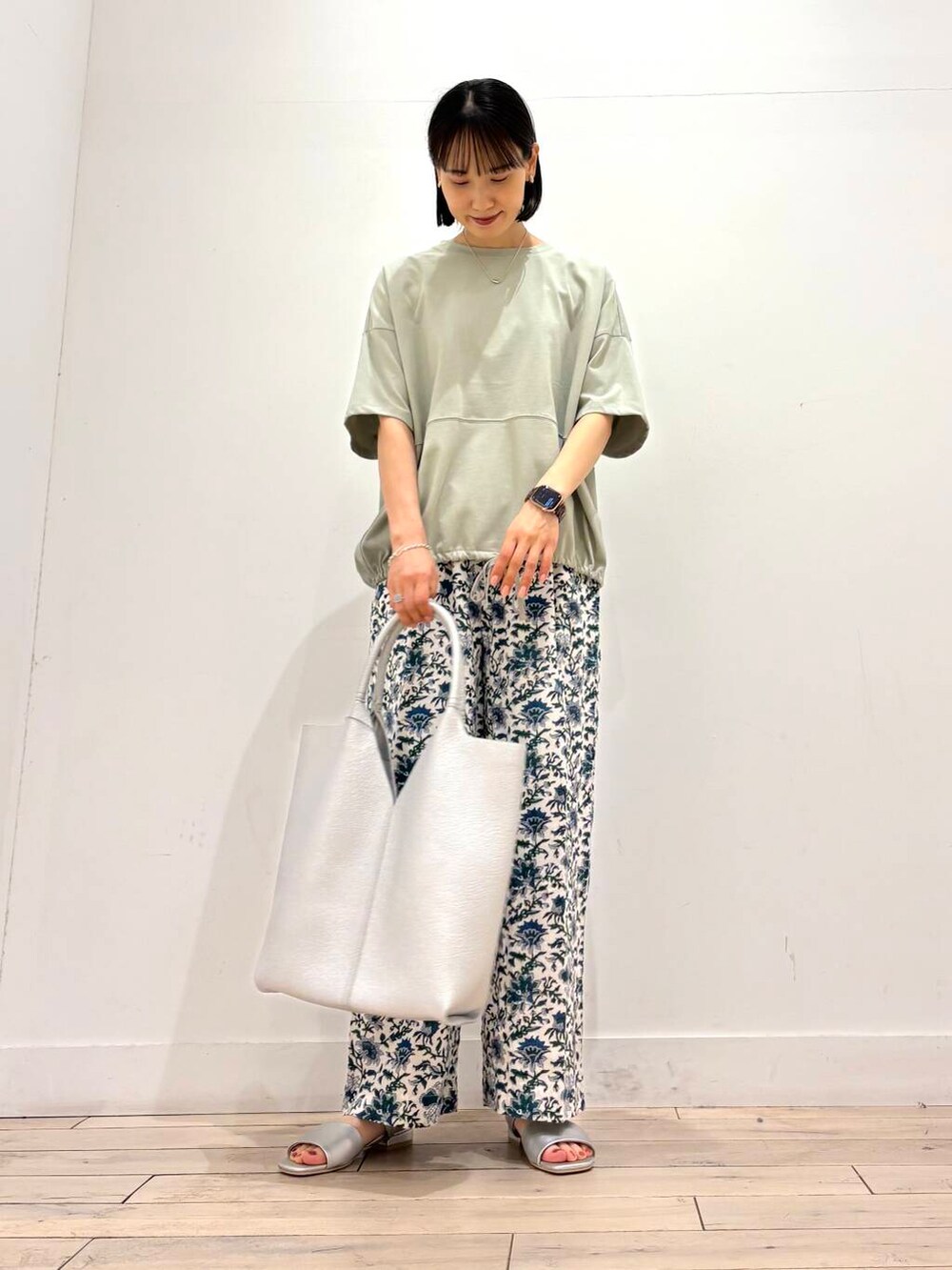 シルバー系のトートバッグ、グリーン系のTシャツ/カットソー、ブルー系のその他パンツを着用したレディースの夏コーディネートの2枚目の写真