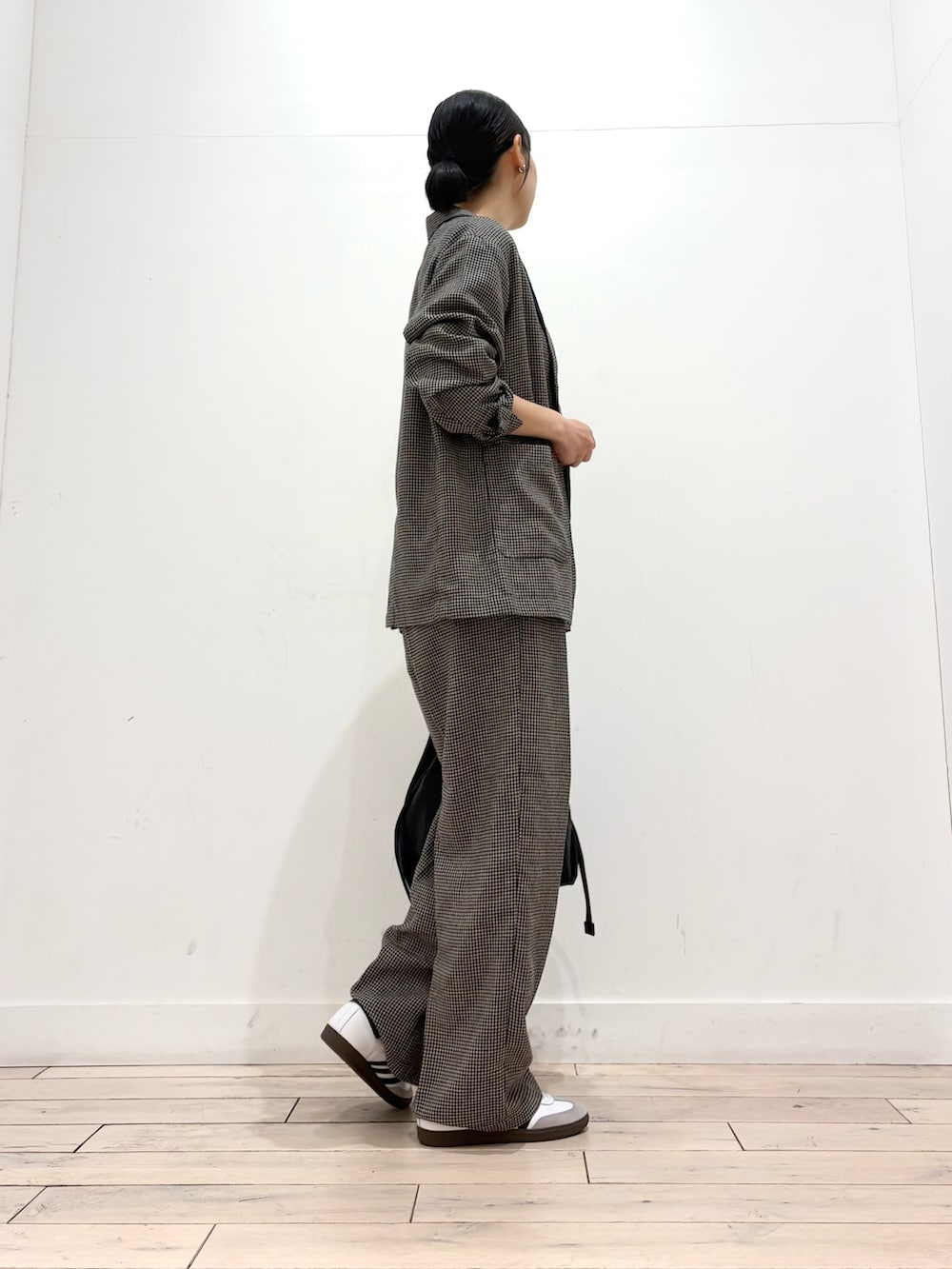 ベージュ系のその他アウター、ブラック系のショルダーバッグ、ホワイト系のスニーカーを着用したレディースの春コーディネートの4枚目の写真