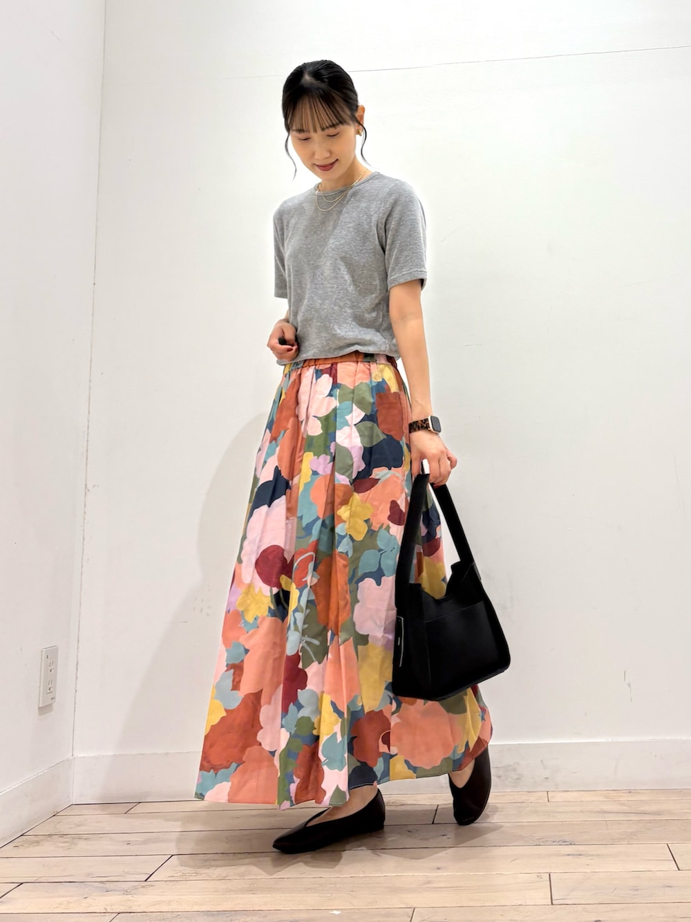 グレー系のTシャツ/カットソー、ピンク系のスカート、ブラック系のハンドバッグを着用したレディースの夏コーディネートの3枚目の写真