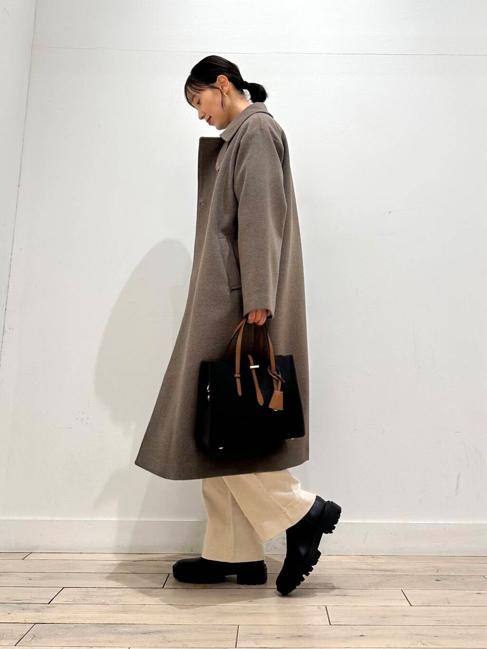 ブラック系のトートバッグ、グリーン系のニット/セーター、ブラック系のブーツを着用したレディースの冬コーディネートの6枚目の写真