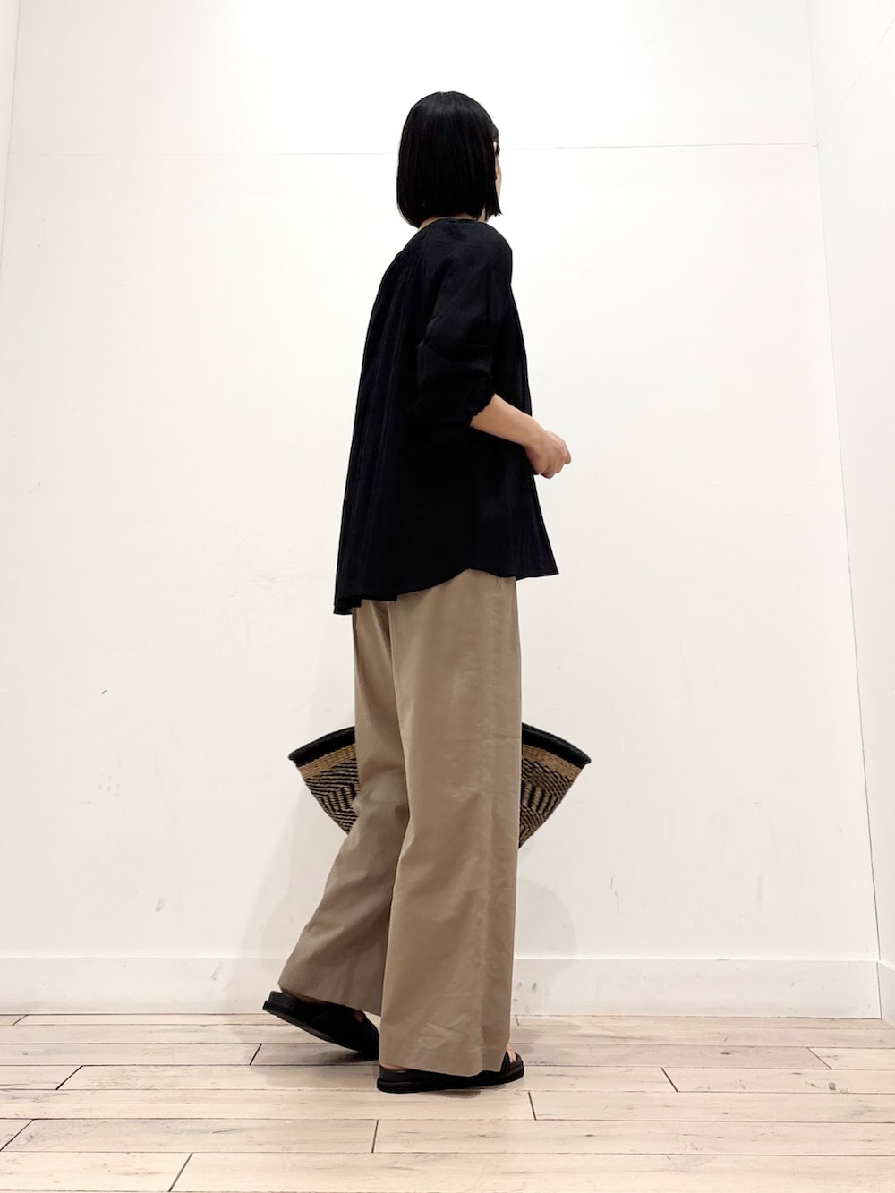 ブラック系のシャツ/ブラウス、ベージュ系のその他パンツ、ブラック系のかごバッグを着用したレディースの春コーディネートの3枚目の写真
