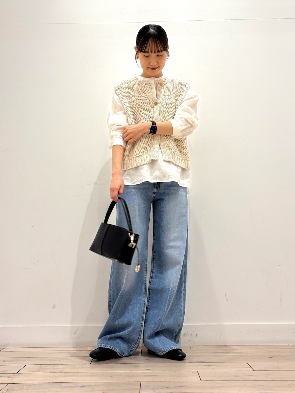 ホワイト系のシャツ/ブラウス、ホワイト系のベスト、ブラック系のショルダーバッグを着用したレディースの春コーディネートの3枚目の写真