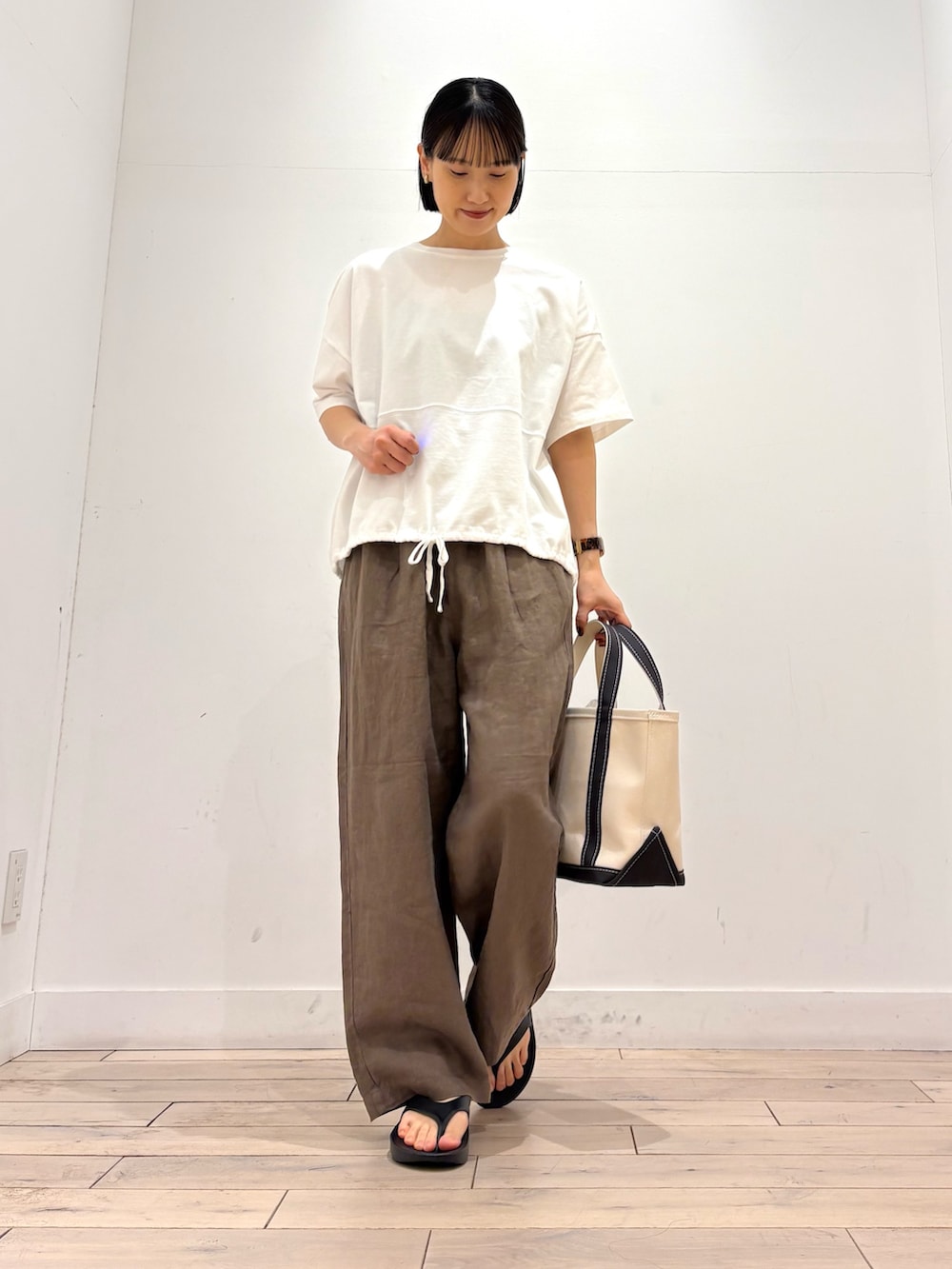 ホワイト系のTシャツ/カットソー、グレー系のトートバッグ、ブラウン系のその他パンツを着用したレディースの春コーディネートの2枚目の写真