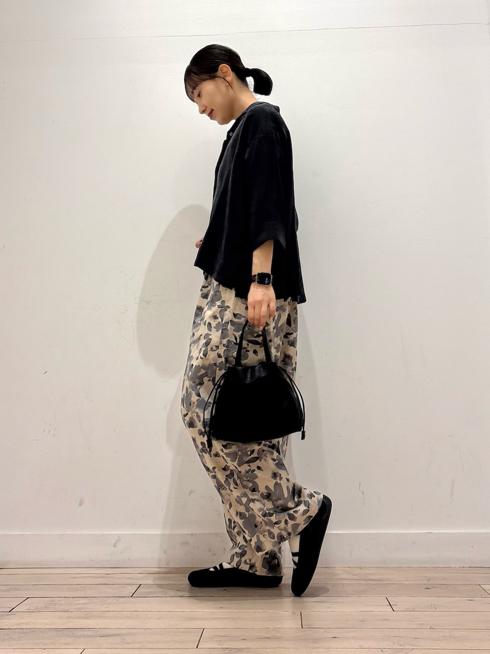 グレー系のその他パンツ、ブラック系のショルダーバッグ、ブラック系のスニーカーを着用したレディースの春コーディネートの2枚目の写真