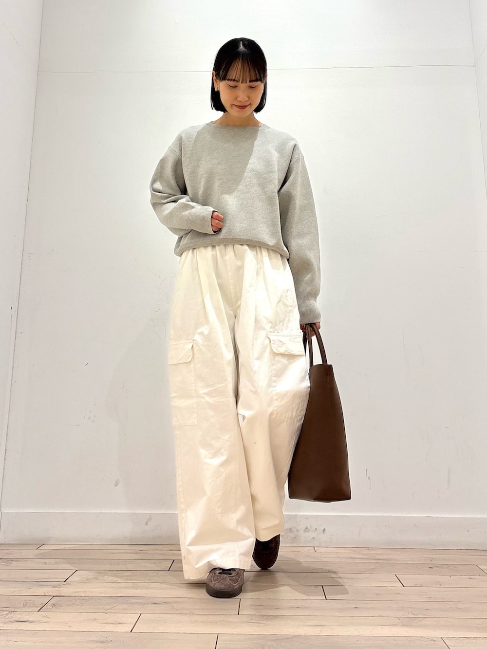 ベージュ系のニット/セーター、ベージュ系のトレンチコート、ブラウン系のトートバッグを着用したレディースの冬コーディネートの5枚目の写真