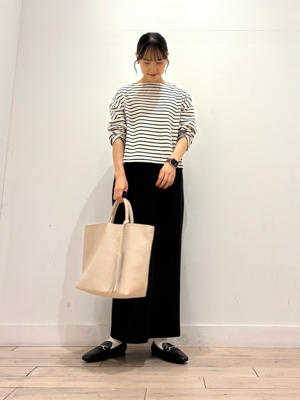 ホワイト系のTシャツ/カットソー、ブラック系のスカート、ホワイト系のトートバッグを着用したレディースの秋コーディネートの2枚目の写真