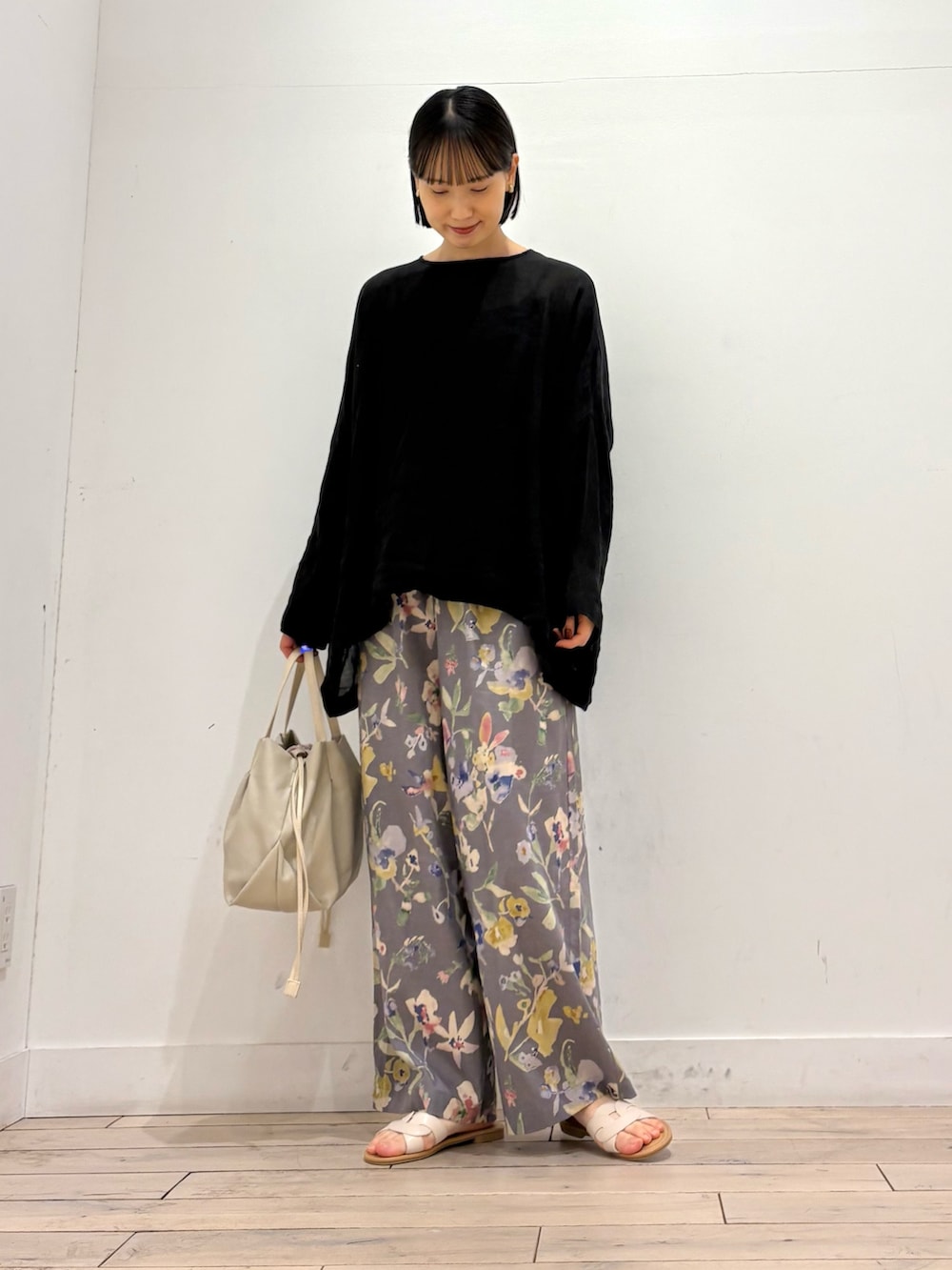 ブラック系のシャツ/ブラウス、グレー系のその他パンツ、ホワイト系のショルダーバッグを着用したレディースの春コーディネートの2枚目の写真