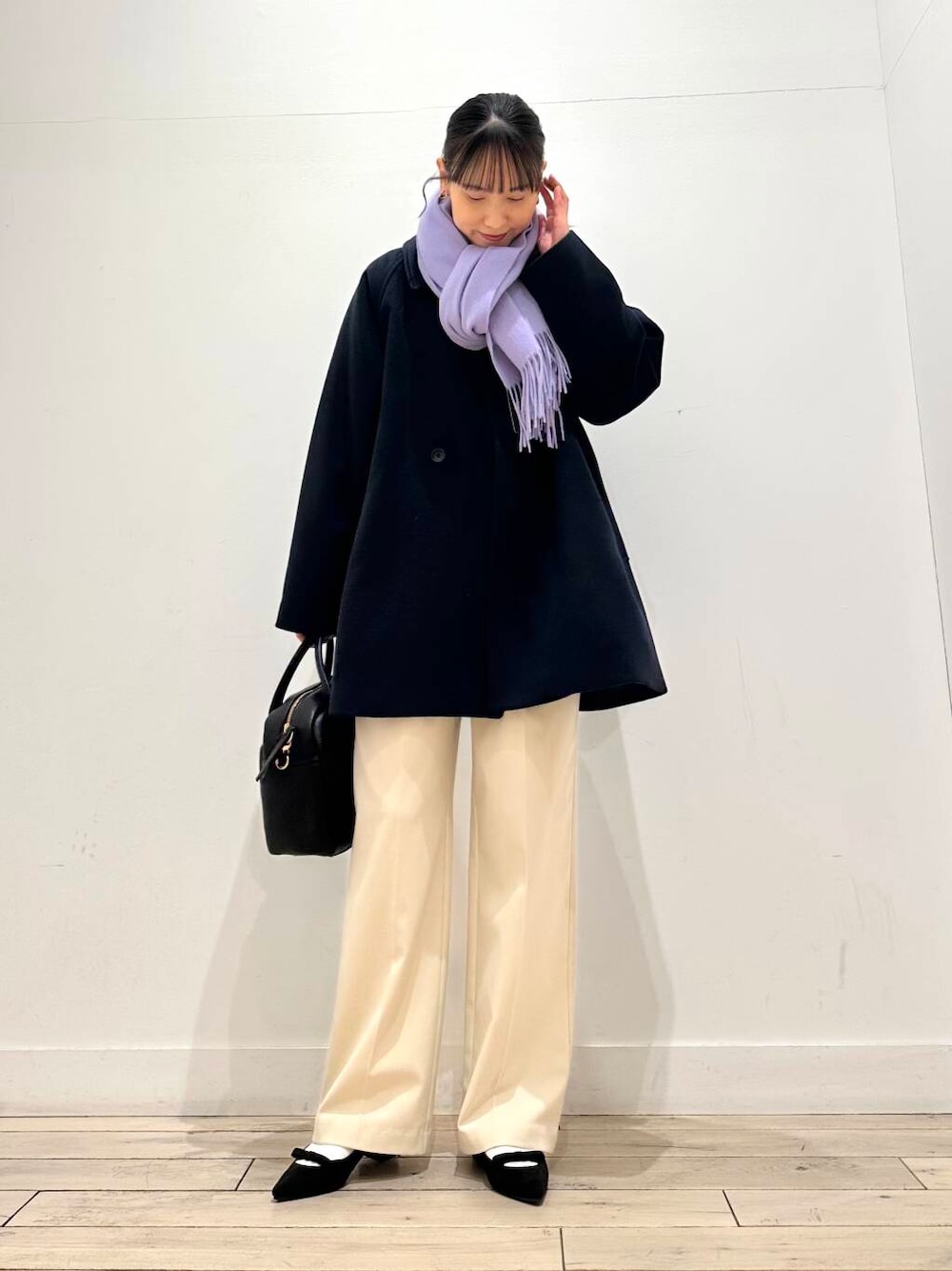 ブラック系のボストンバッグ、ブラック系のパンプス、ブルー系のステンカラーコートを着用したレディースの冬コーディネートの2枚目の写真