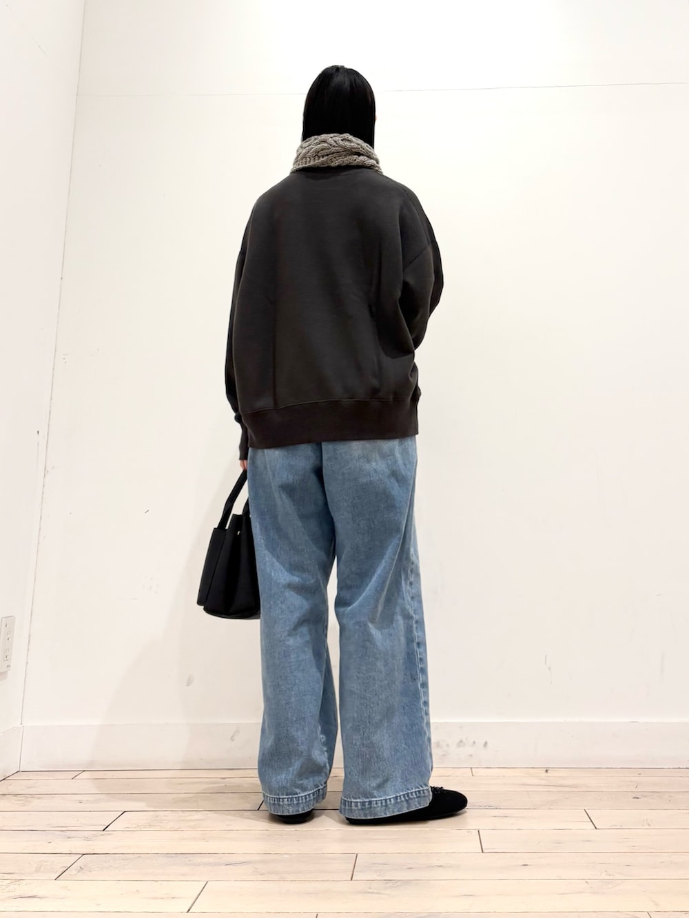 グレー系のスウェット、ブルー系のデニムパンツ、ブラック系のトートバッグを着用したレディースの冬コーディネートの5枚目の写真