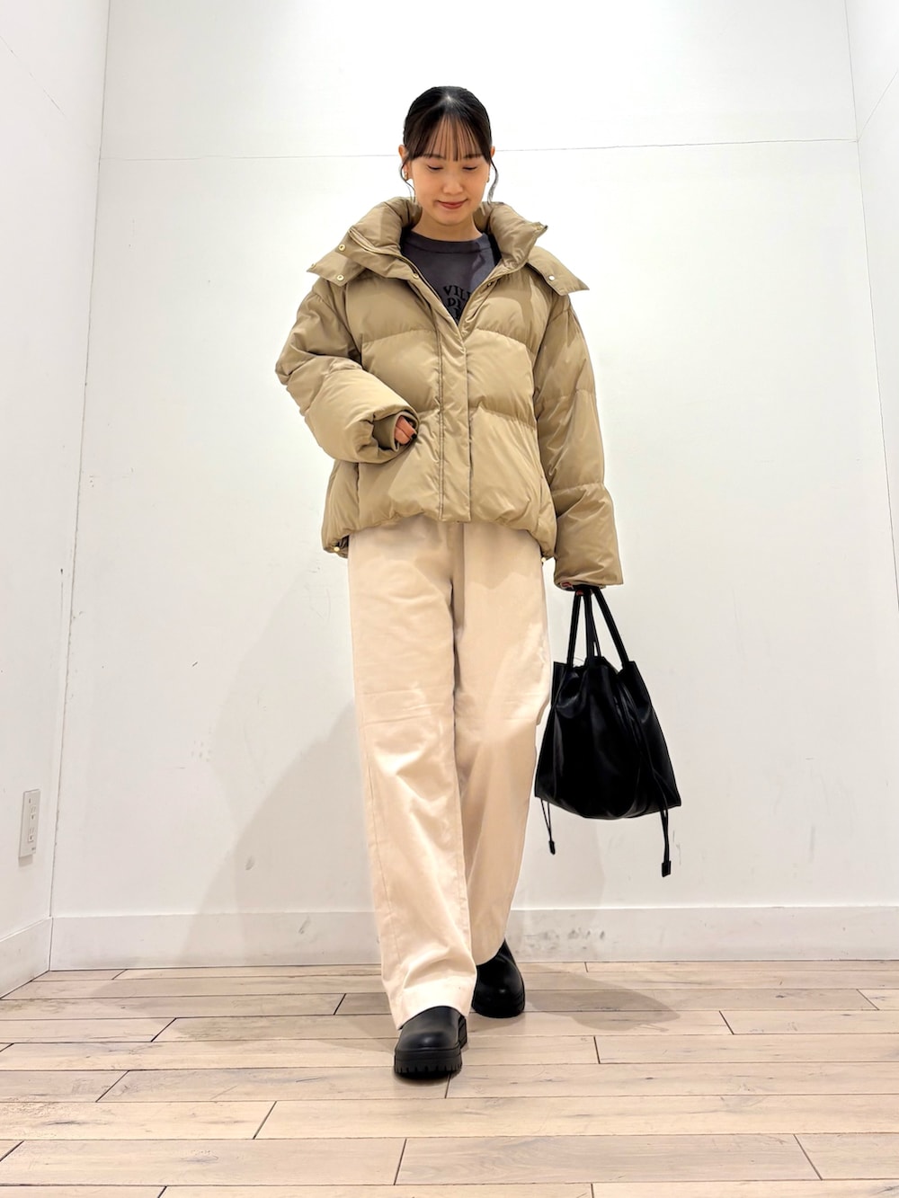 グレー系のニット/セーター、ベージュ系のダウンジャケット/コート、ホワイト系のその他パンツを着用したレディースの冬コーディネートの2枚目の写真