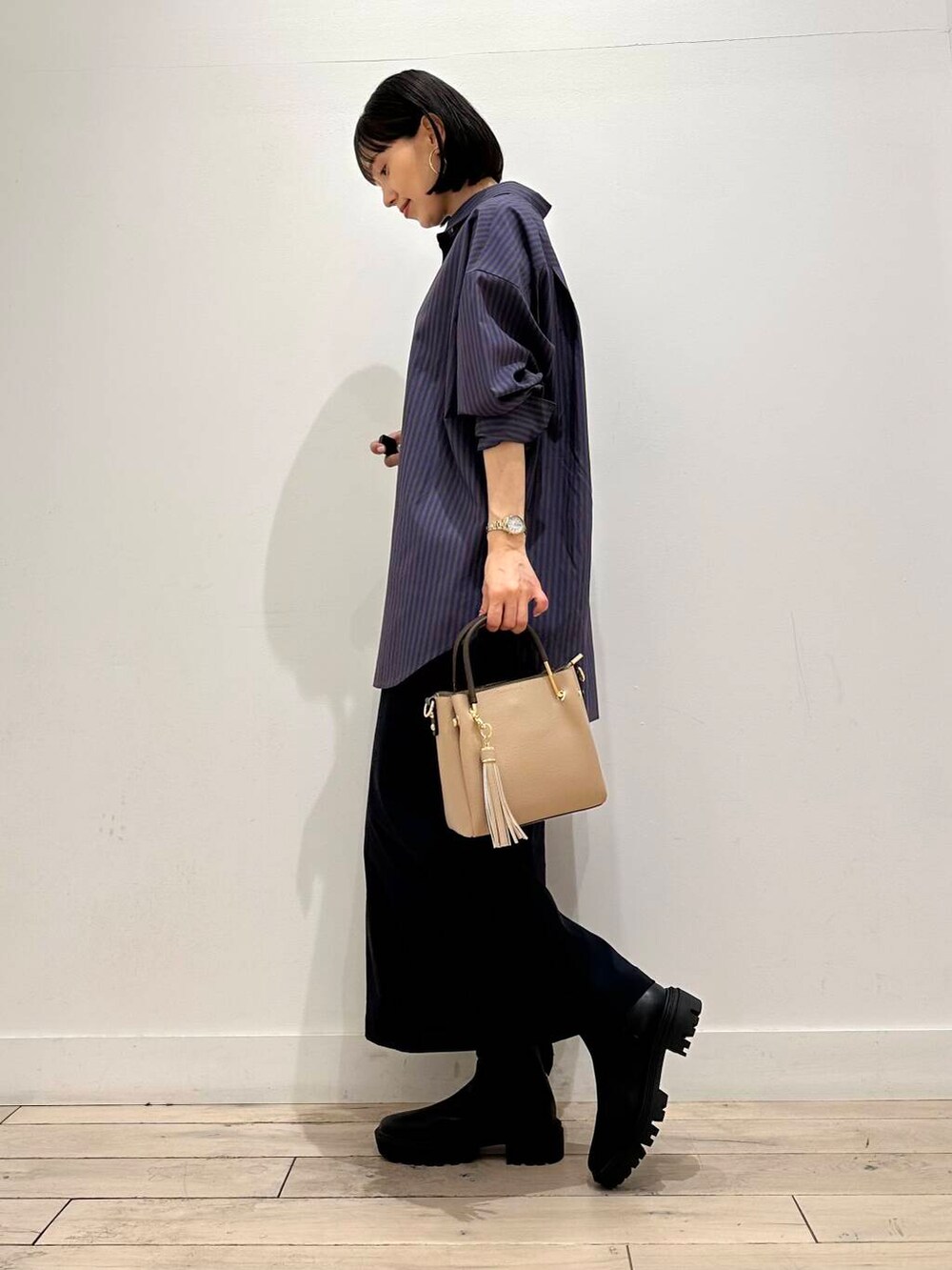 ベージュ系のトートバッグ、ブラック系のブーツ、ブルー系のシャツ/ブラウスを着用したレディースの秋コーディネートの3枚目の写真