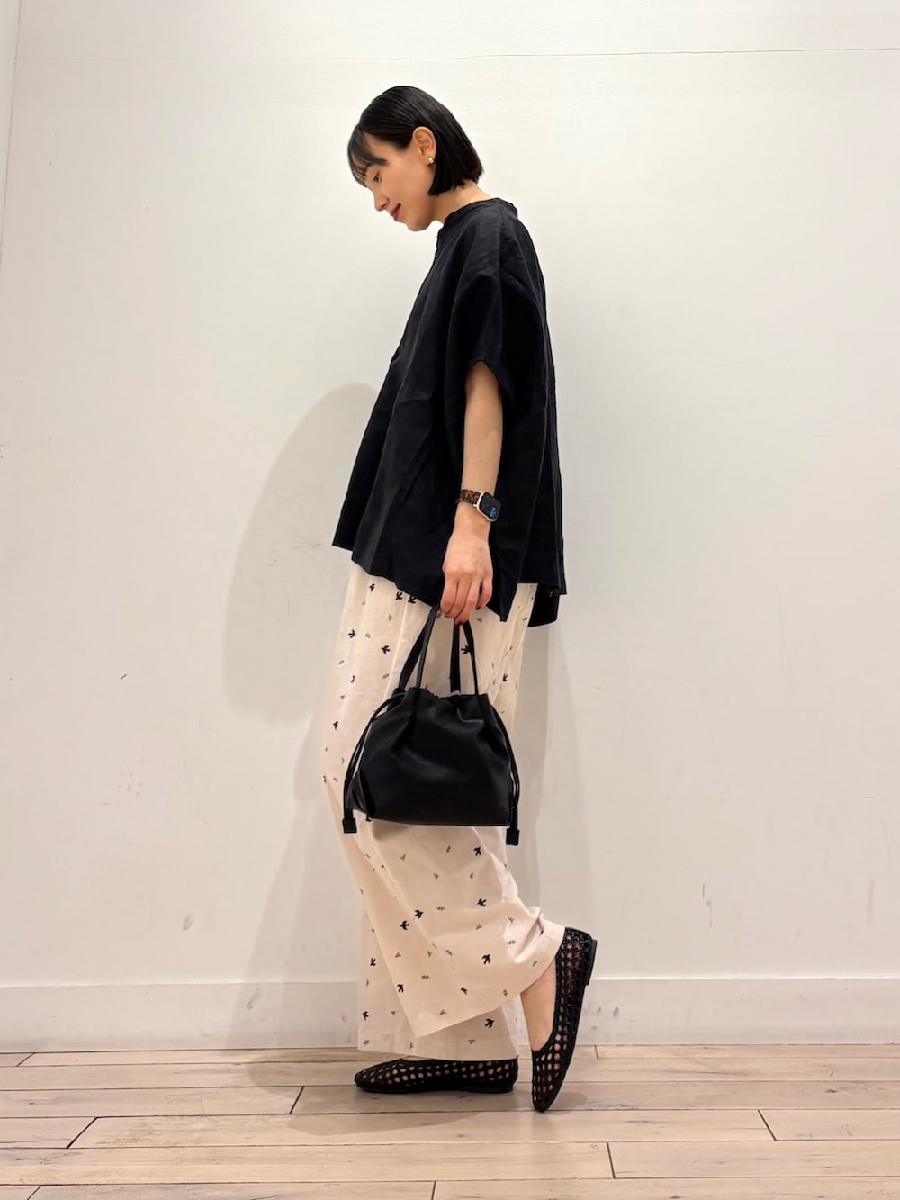 ブラック系のサンダル、ホワイト系のその他パンツ、ブラック系のショルダーバッグを着用したレディースの春コーディネートの2枚目の写真