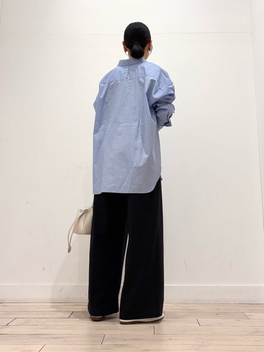 ブルー系のシャツ/ブラウス、ブラック系のその他パンツ、ホワイト系のショルダーバッグを着用したレディースの春コーディネートの3枚目の写真