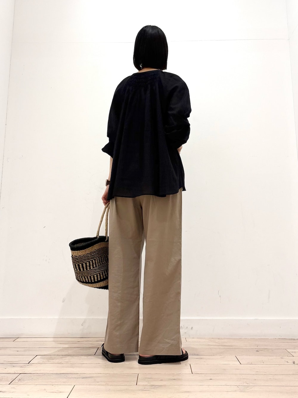 ブラック系のシャツ/ブラウス、ベージュ系のその他パンツ、ブラック系のかごバッグを着用したレディースの春コーディネートの4枚目の写真