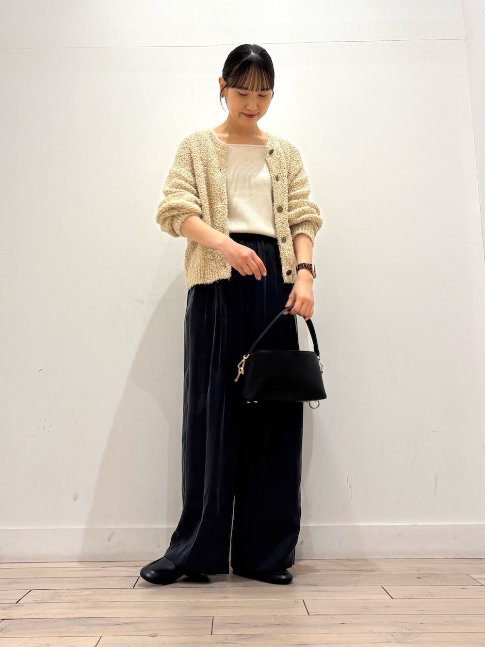 ホワイト系のタンクトップ、イエロー系のカーディガン/ボレロ、ブラック系のその他パンツを着用したレディースの春コーディネートの3枚目の写真