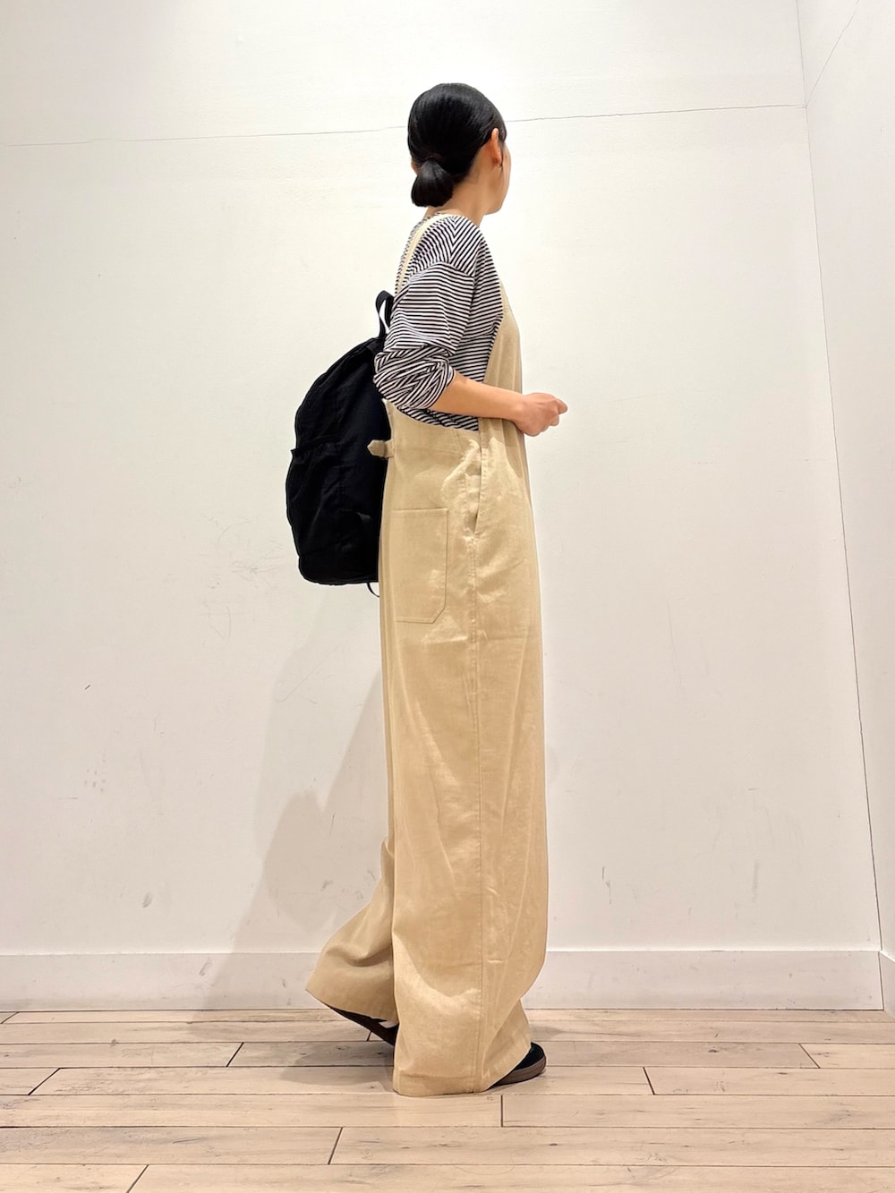 ブラック系のTシャツ/カットソー、ブラック系のバックパック/リュック、ブラック系のスニーカーを着用したレディースの春コーディネートの3枚目の写真