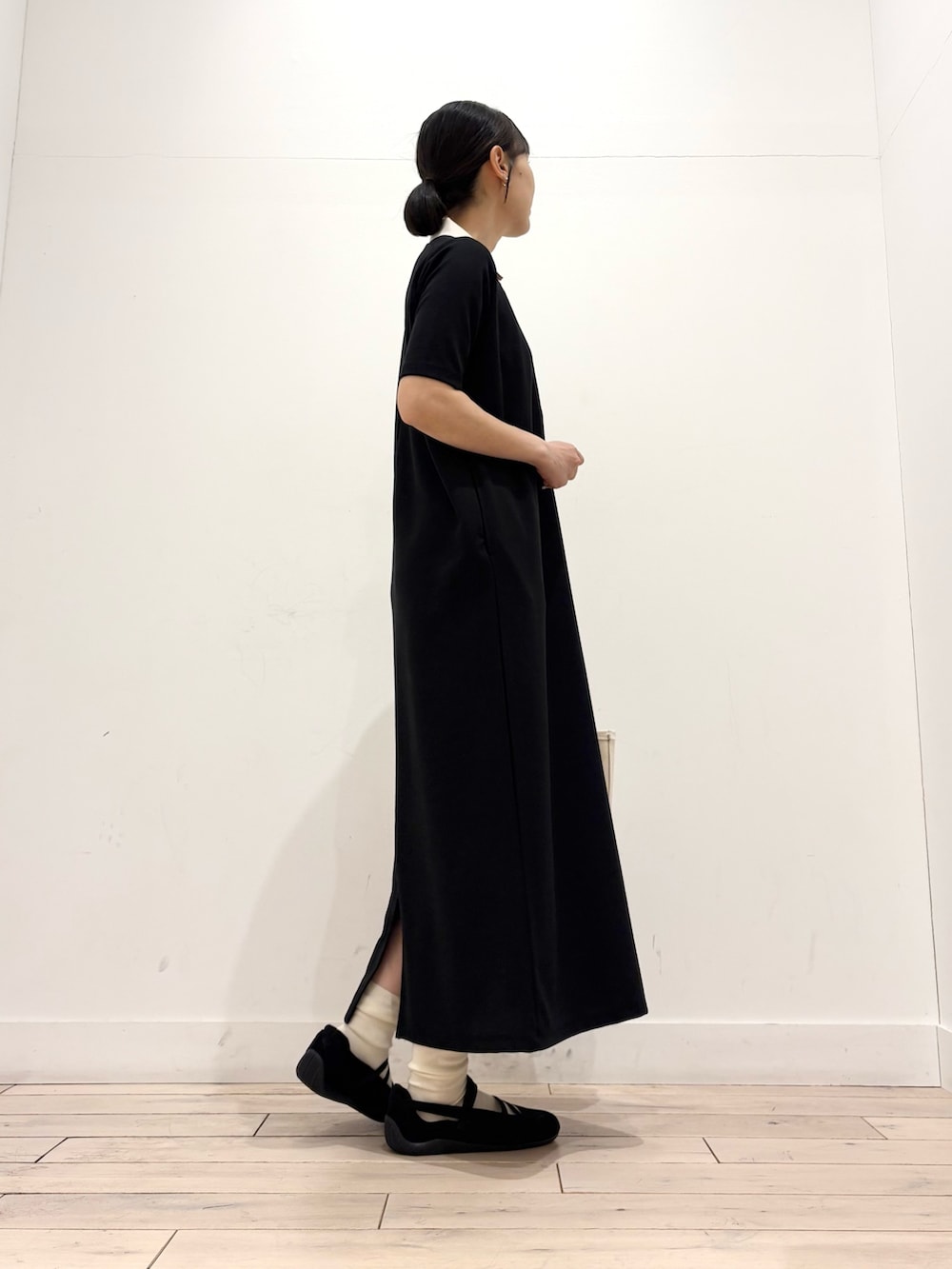 ブラック系のワンピース、グレー系のトートバッグ、ブラック系のスニーカーを着用したレディースの春コーディネートの5枚目の写真