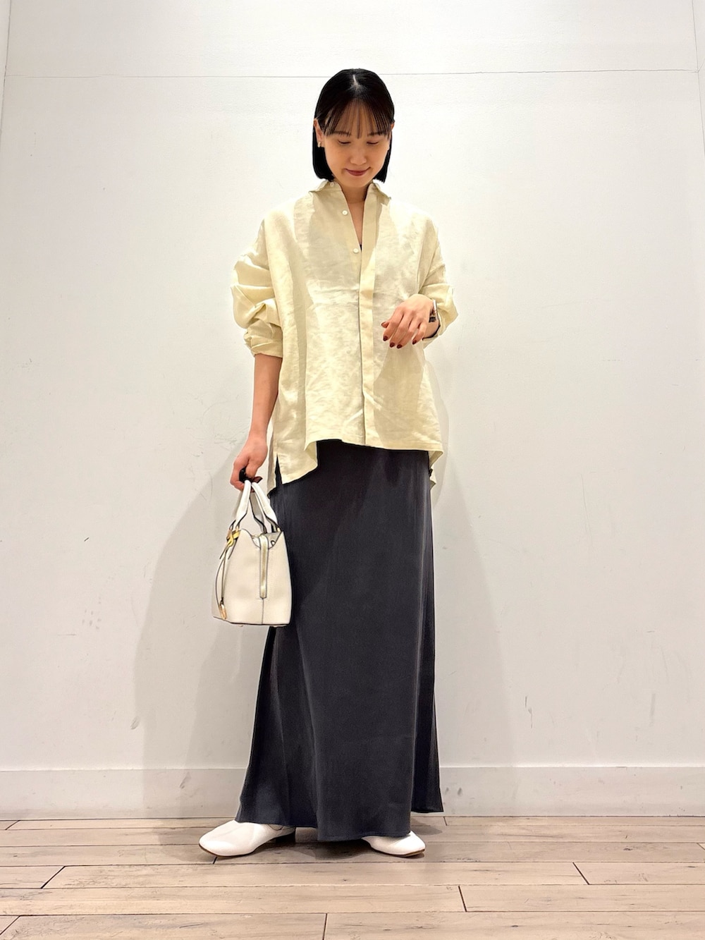 イエロー系のシャツ/ブラウス、ホワイト系のその他シューズ、グレー系のスカートを着用したレディースの春コーディネートの2枚目の写真