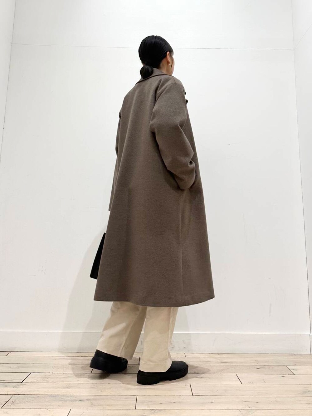 ブラック系のトートバッグ、グリーン系のニット/セーター、ブラック系のブーツを着用したレディースの冬コーディネートの7枚目の写真