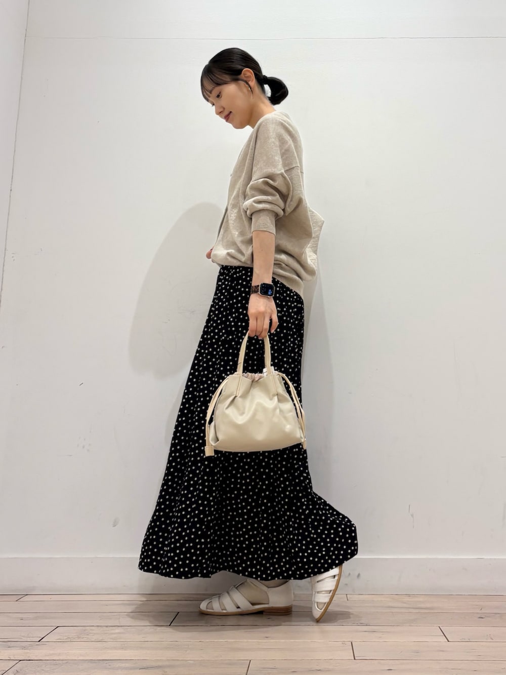 ブラック系のスカート、ホワイト系のショルダーバッグ、ホワイト系のサンダルを着用したレディースの春コーディネートの3枚目の写真