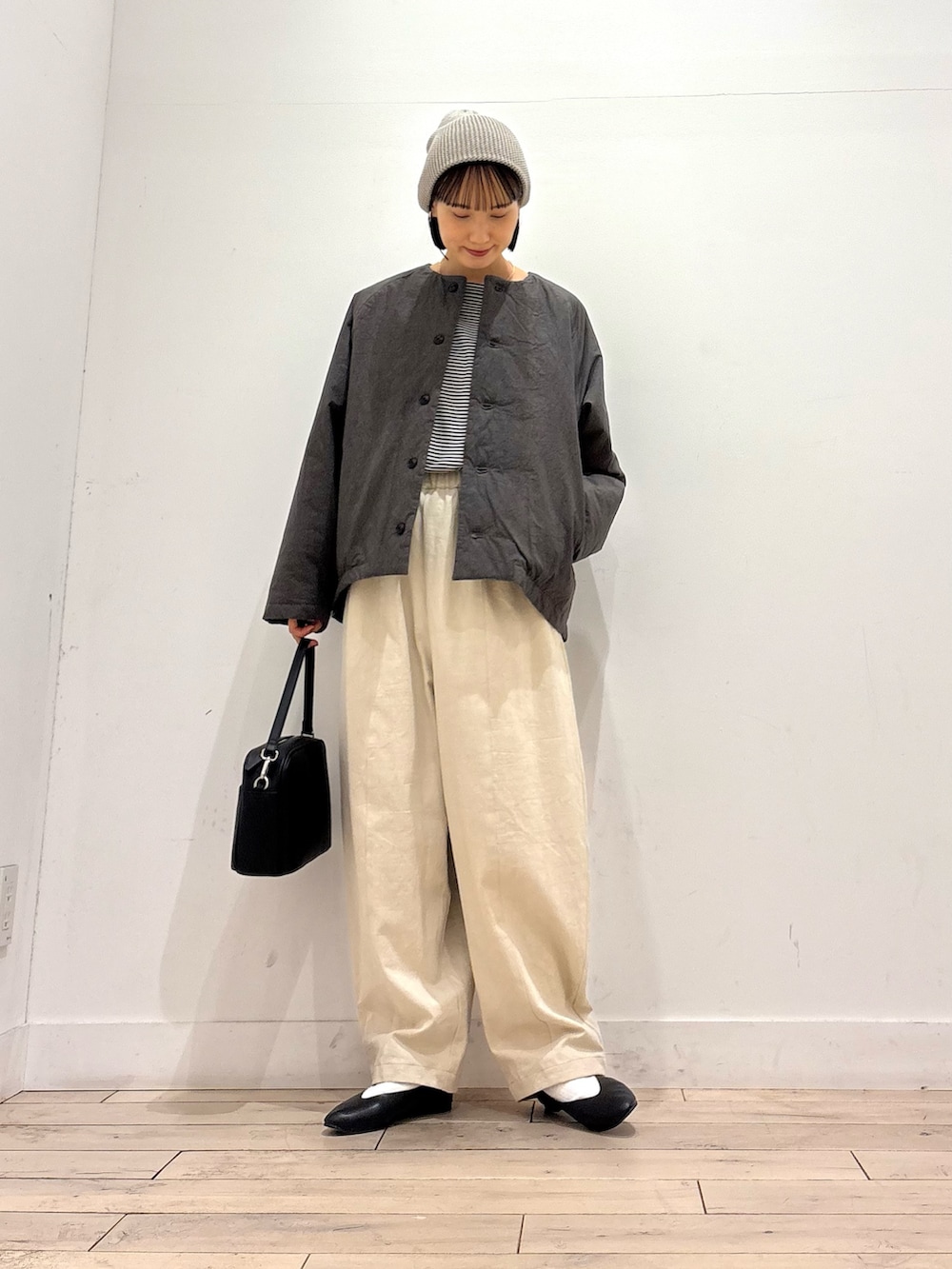 グレー系のダウンジャケット/コート、ブラック系のTシャツ/カットソー、ホワイト系のその他パンツを着用したレディースの秋コーディネートの2枚目の写真