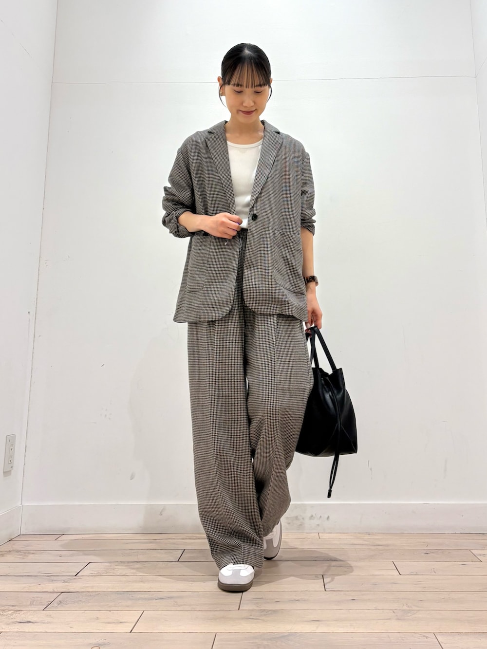 ベージュ系のその他アウター、ブラック系のショルダーバッグ、ホワイト系のスニーカーを着用したレディースの春コーディネートの2枚目の写真