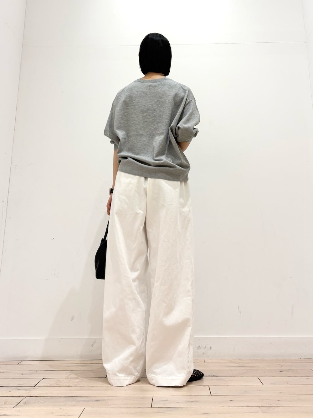 グレー系のTシャツ/カットソー、ブラック系のショルダーバッグ、ブラック系のサンダルを着用したレディースの春コーディネートの4枚目の写真