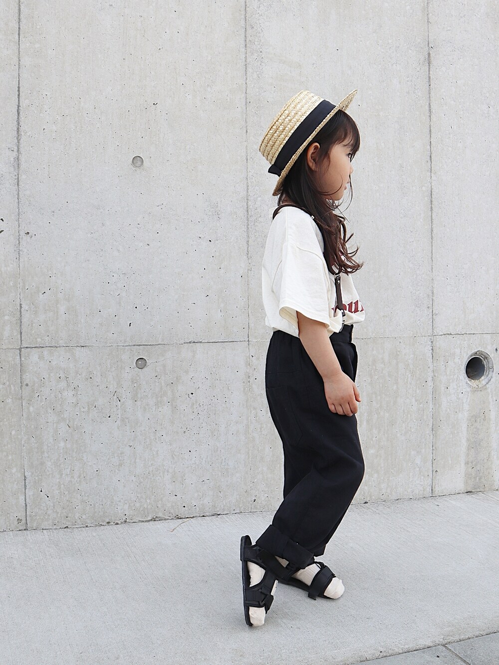 ホワイト系のパンツ、ブラック系のサンダル、ホワイト系のTシャツ/カットソーを着用したキッズの春コーディネートの2枚目の写真