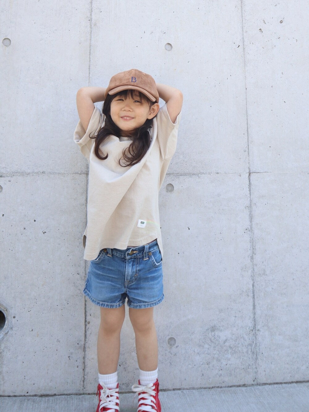 レッド系のスニーカー、ブルー系のデニムパンツ、ベージュ系のTシャツ/カットソーを着用したキッズの春コーディネートの4枚目の写真