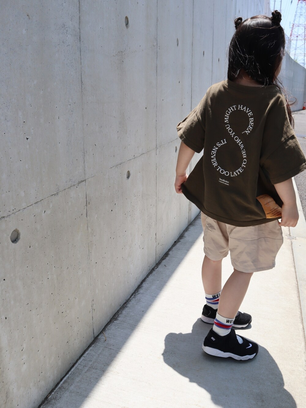 グリーン系のTシャツ/カットソー、ベージュ系のパンツ、ブラック系のサンダルを着用したキッズの春コーディネートの2枚目の写真