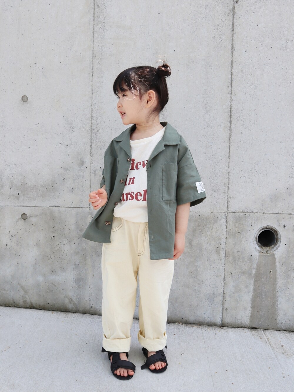 ホワイト系のパンツ、ブラック系のサンダル、ホワイト系のTシャツ/カットソーを着用したキッズの春コーディネートの3枚目の写真