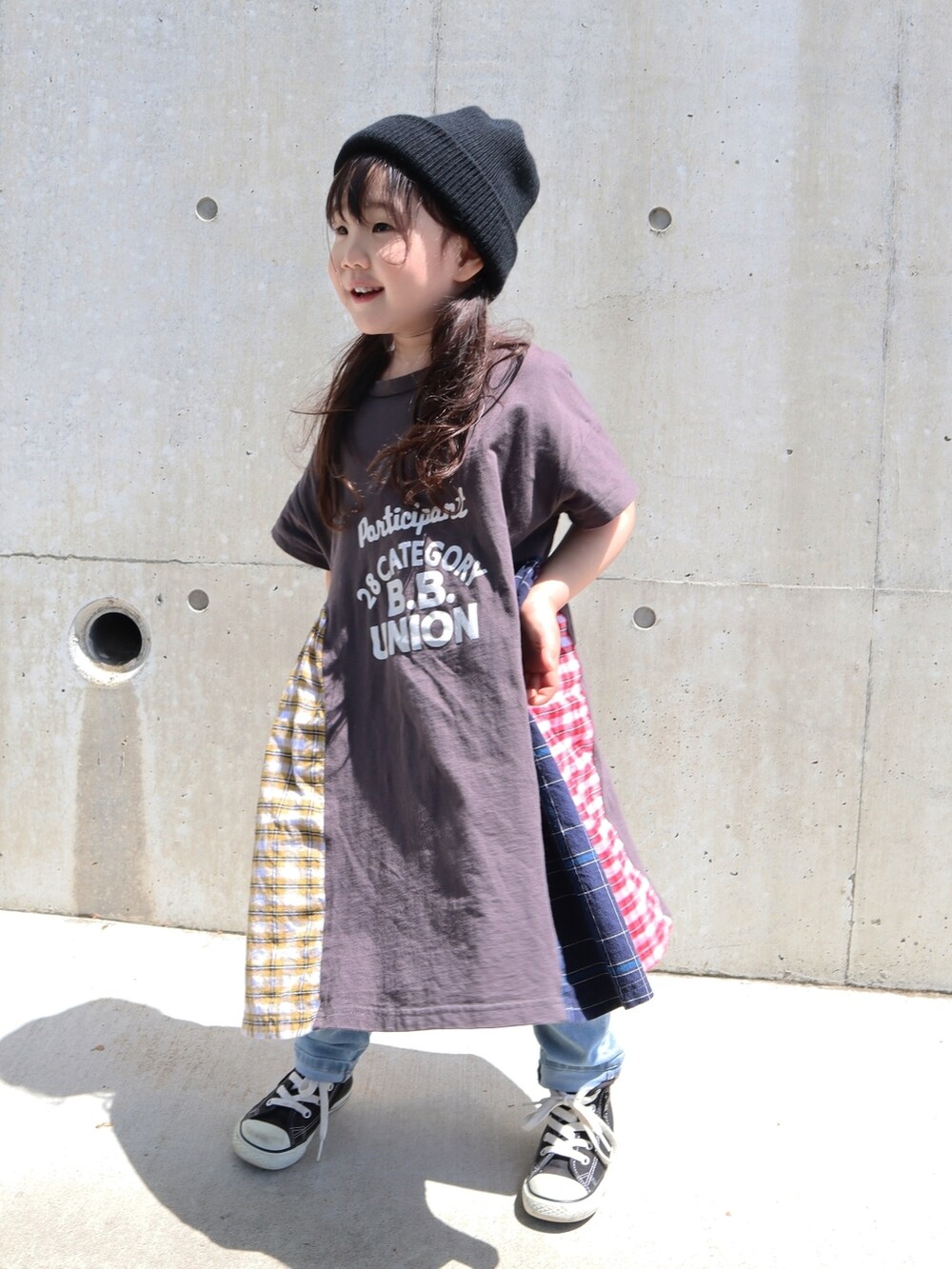 ブラック系のワンピース/ドレス、ブラック系のスニーカー、ブルー系のデニムパンツを着用したキッズの春コーディネートの3枚目の写真