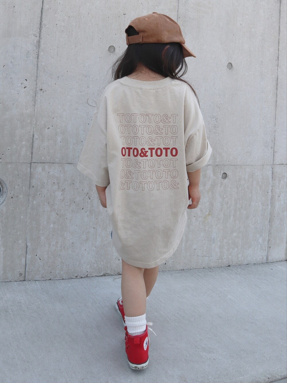 レッド系のスニーカー、ブルー系のデニムパンツ、ベージュ系のTシャツ/カットソーを着用したキッズの春コーディネートの3枚目の写真