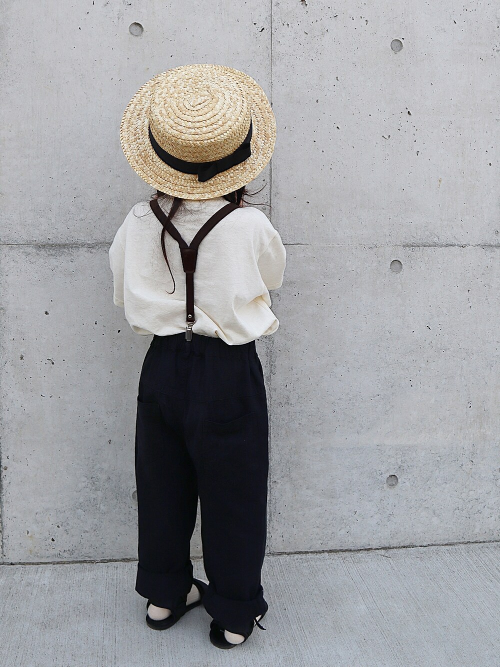 ホワイト系のパンツ、ブラック系のサンダル、ホワイト系のTシャツ/カットソーを着用したキッズの春コーディネートの3枚目の写真